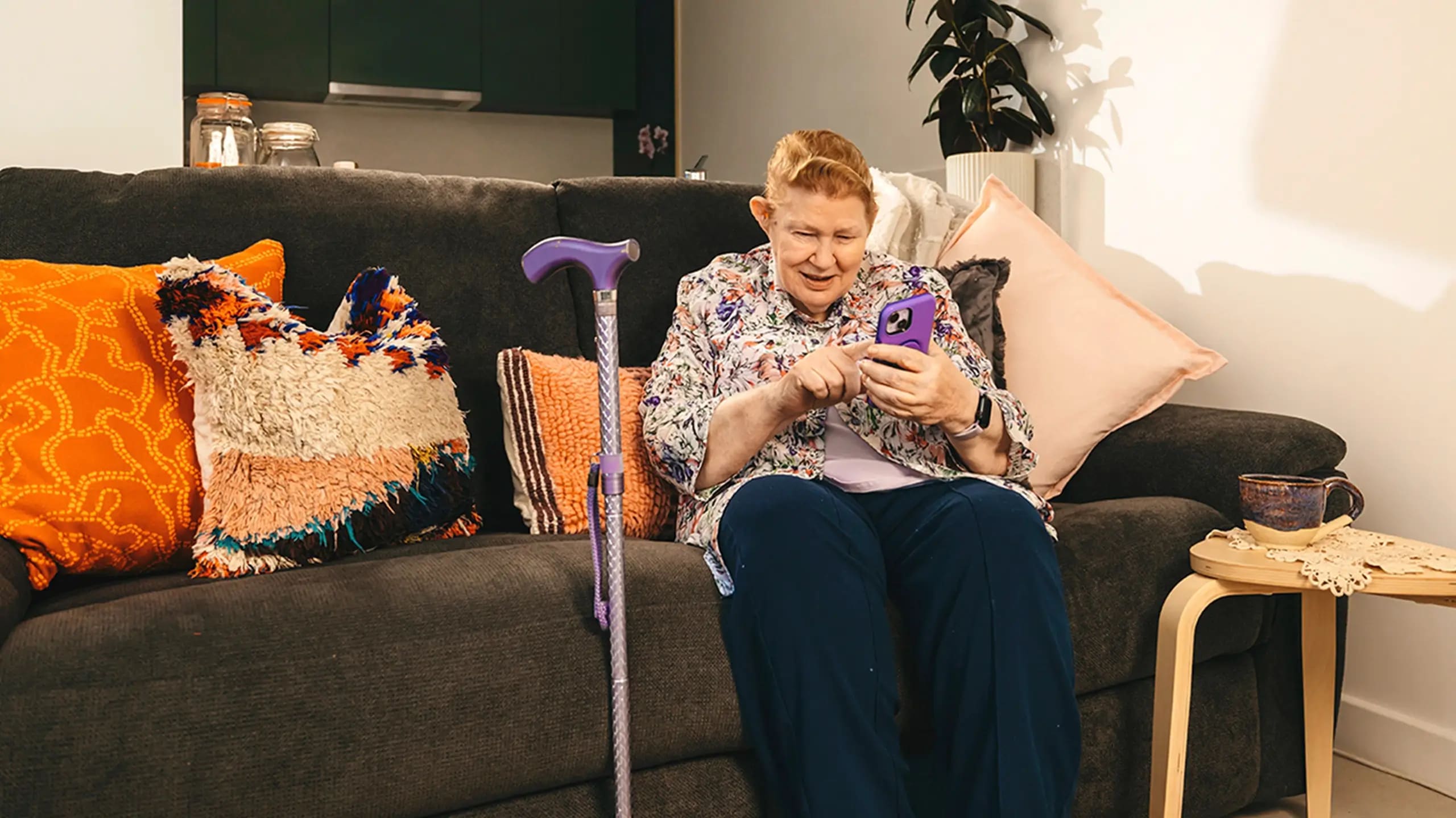 An older client looks at the Mable app on her smartphone.