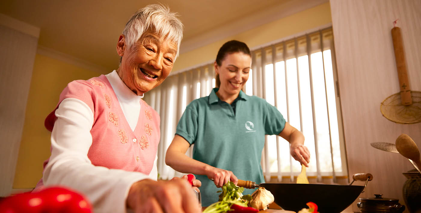 A support worker and her client prepare a meal together.