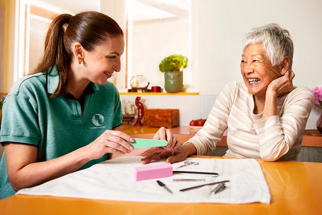 A support worker provides personal assistance to an elderly woman