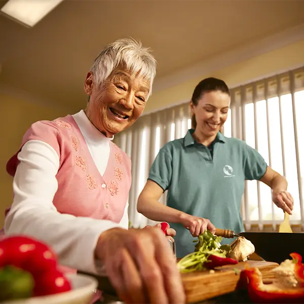 A support worker and her client prepare a meal together.