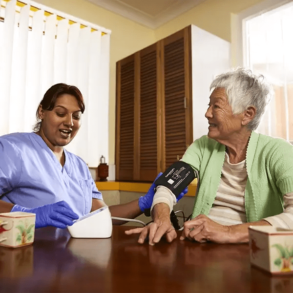 A nurse takes an older woman's blood pressure.
